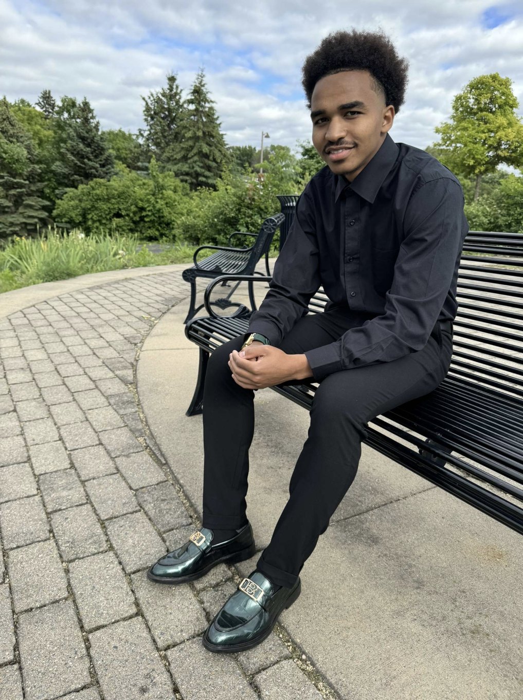 Ayub Mohamed, founder of Growth Lab, seated outdoors in a black button-up shirt